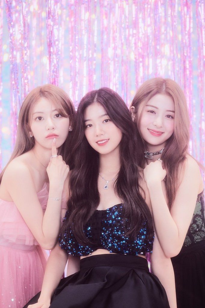 three young women posing for the camera in front of a pink background with sequins