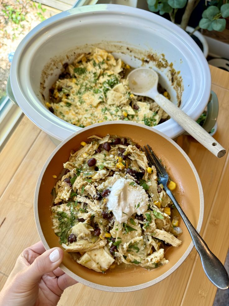 two bowls filled with food on top of a wooden table