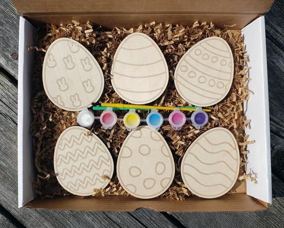 four wooden easter eggs in a cardboard box