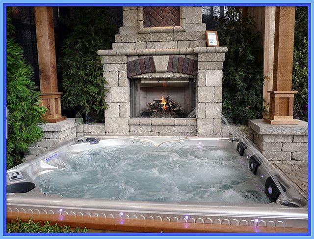 a hot tub sitting in front of a fire place