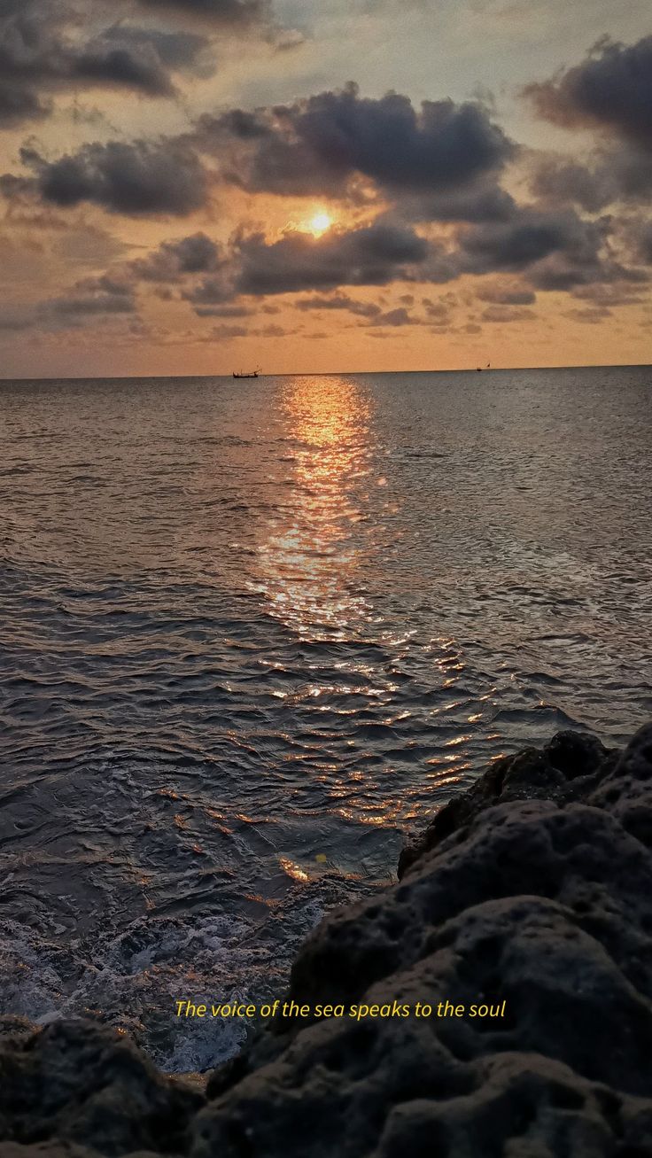 the sun is setting over the ocean with clouds in the sky and water below it