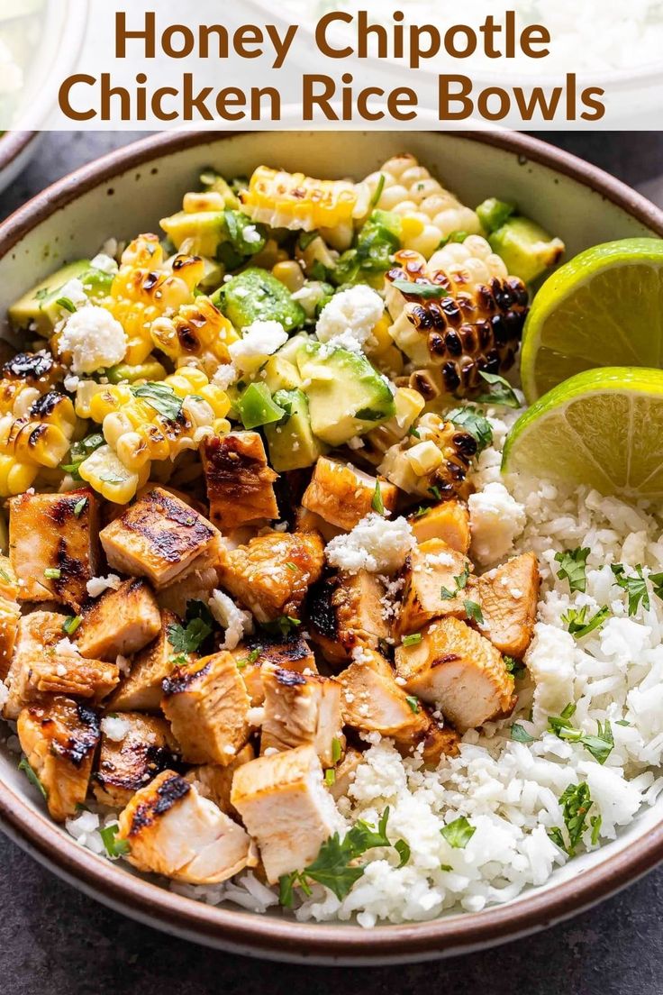 two bowls filled with chicken and rice next to a lime wedge on the side,