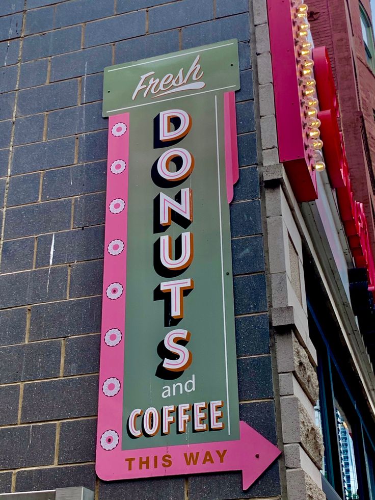 a sign on the side of a building advertising doughnuts and coffee