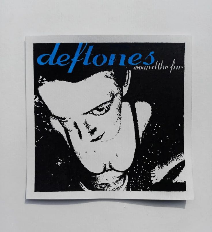 a close up of a sticker on a wall with the words deftones written in blue