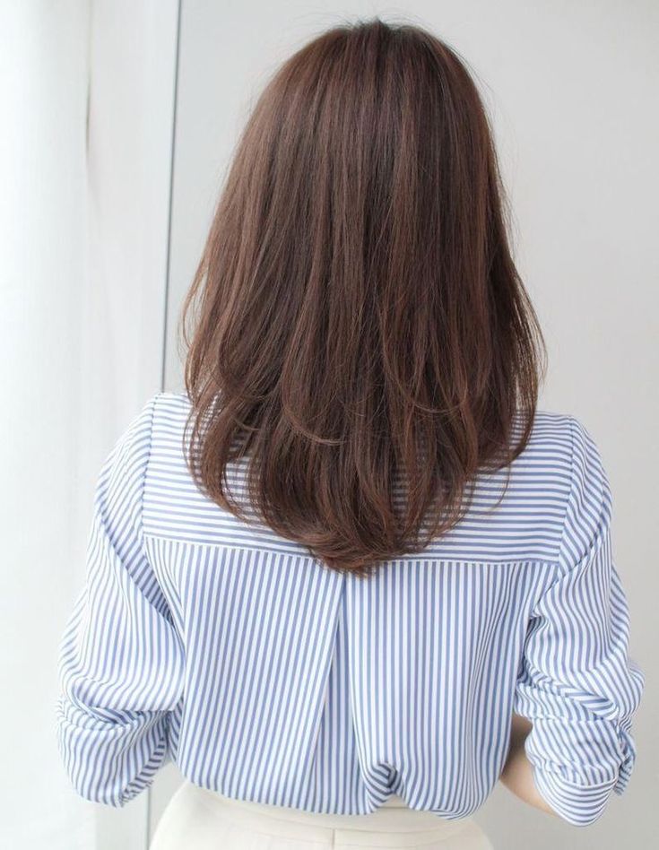 the back of a woman's head wearing a blue and white striped shirt