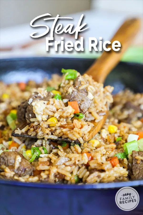 beef fried rice in a blue bowl with a wooden spoon and title overlay reads steak fried rice