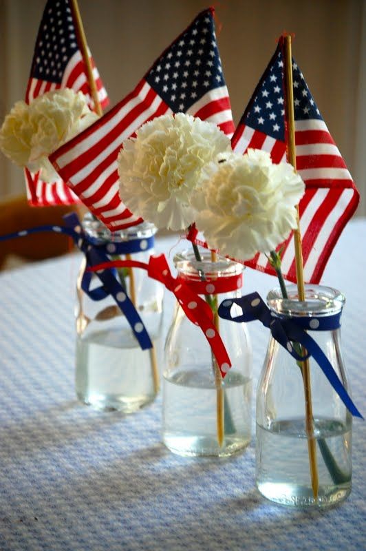 three vases with american flags and flowers in them