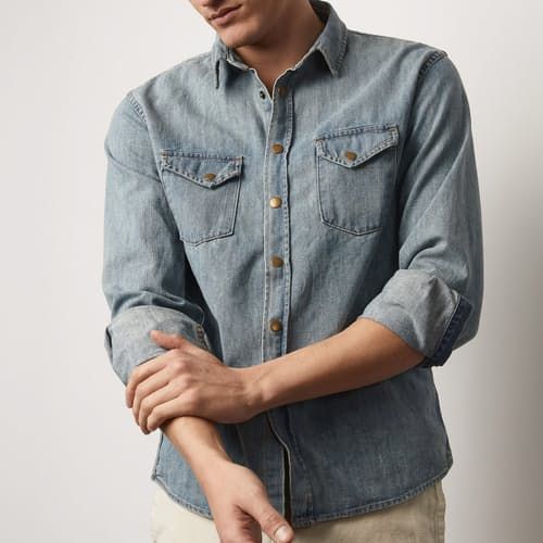 Distressed to perfection, this denim shirt is well-worn and wears well Unstructured Medium Wash Denim Shirt, Unstructured Denim Shirt In Medium Wash, Faded Denim Button-up Tops, Classic Distressed Cotton Denim Jacket, Distressed Faded Denim Tops, Faded Distressed Denim Tops, Distressed Denim Tops In Faded Color, Classic Washed Denim Button-up Top, Classic Washed Button-up Denim Top