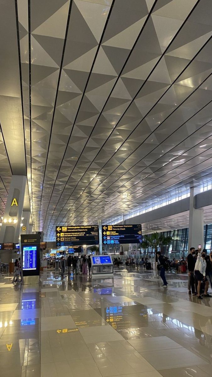 many people are walking through an airport terminal