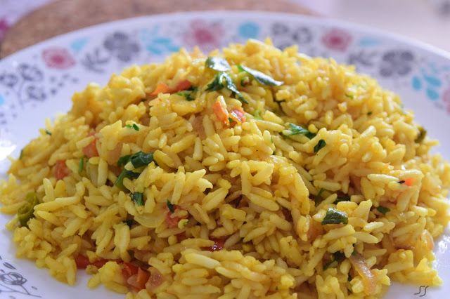 a white plate topped with yellow rice and vegetables