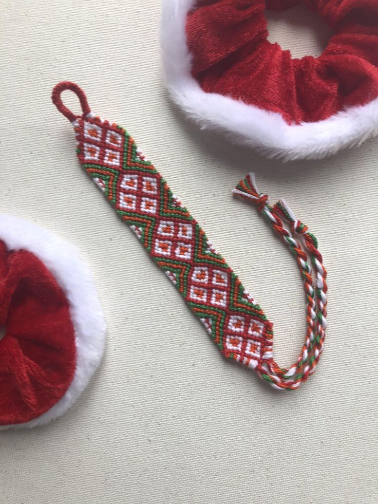 two pieces of red and white fabric on top of a table next to a pair of headbands