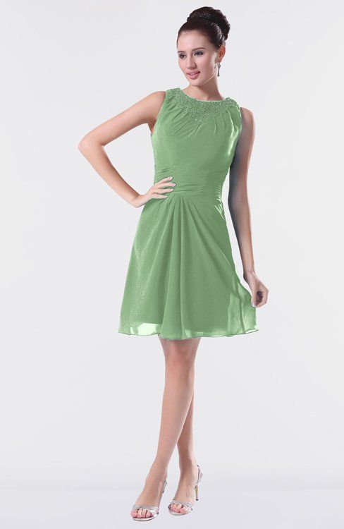 a woman in a short green dress posing for the camera