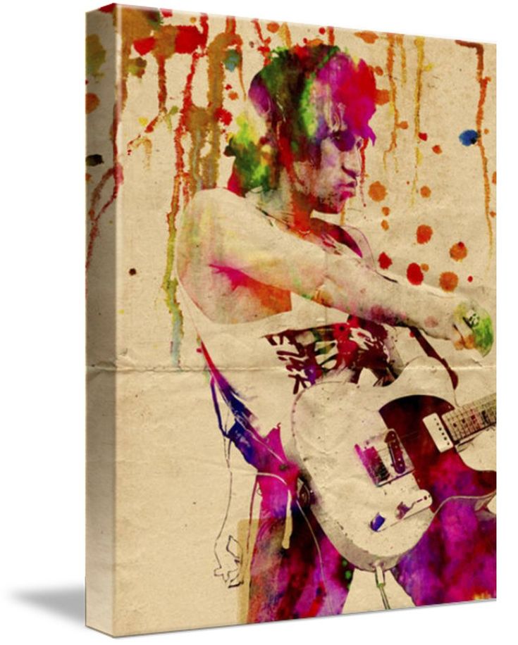 a man with a guitar in his hand and paint splatters on the wall behind him