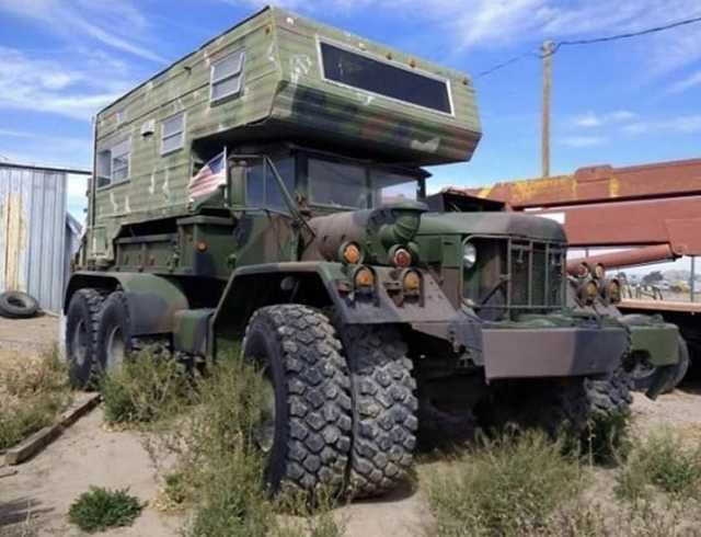 an army truck is parked in the dirt