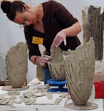 a woman is making clay sculptures on a table