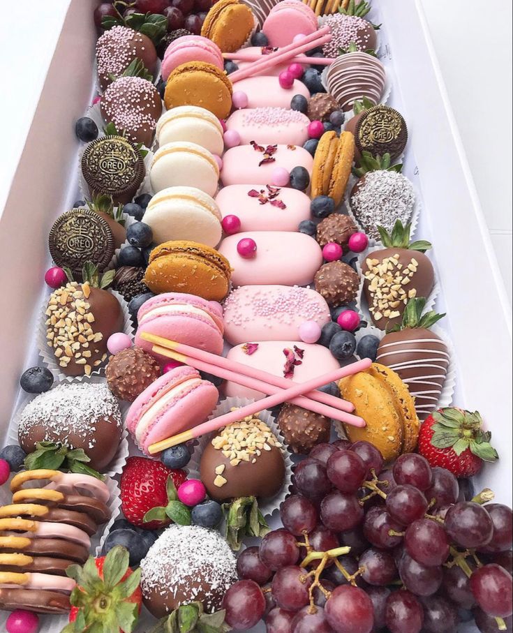 a long tray filled with lots of different types of donuts and other pastries