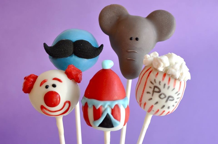 some kind of cake pops with clown faces and mustaches on them in front of a purple background