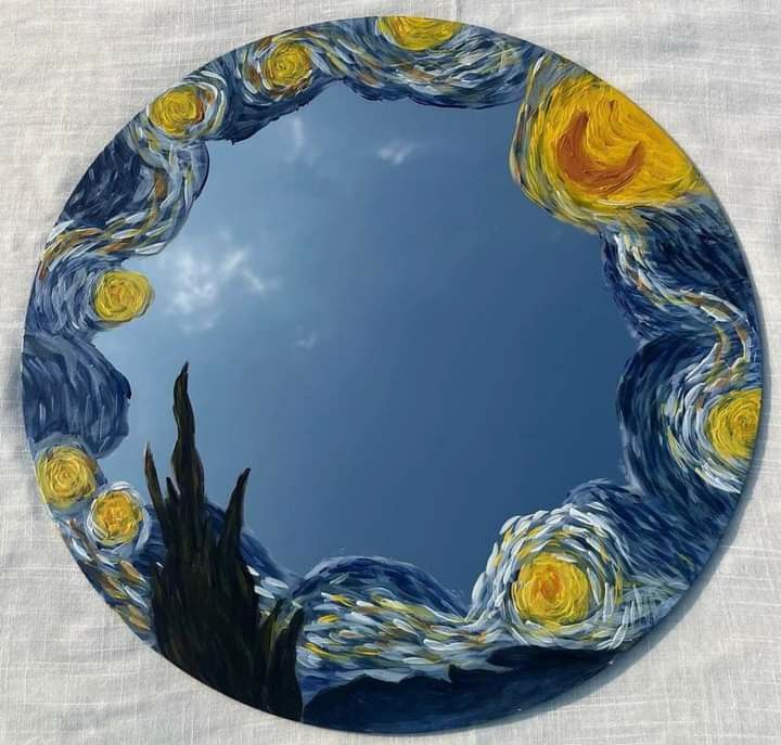 a round mirror with the starry night painting on it