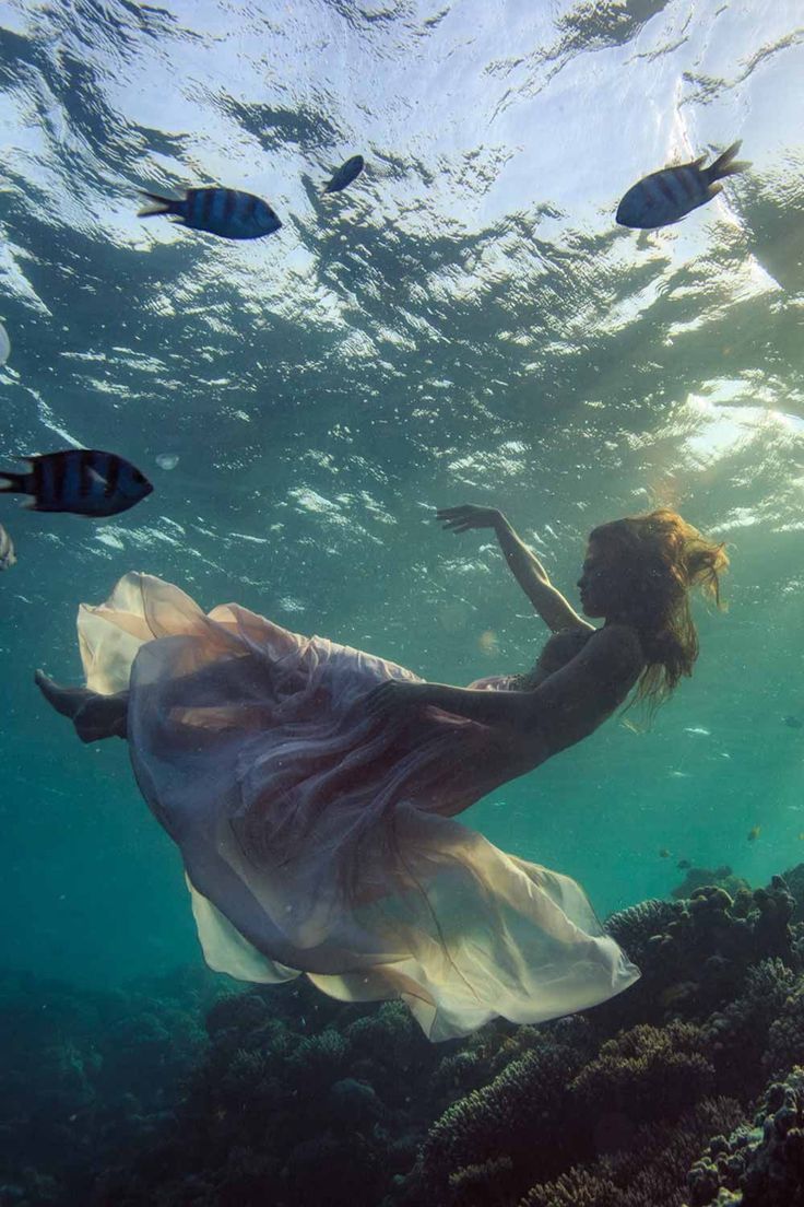 a woman in a white dress under water