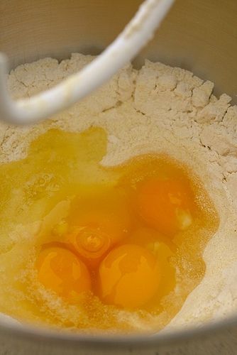 three eggs in a bowl with flour