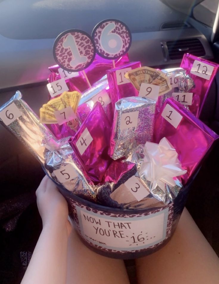 a basket filled with lots of candy sitting on top of a car dash board in someone's lap