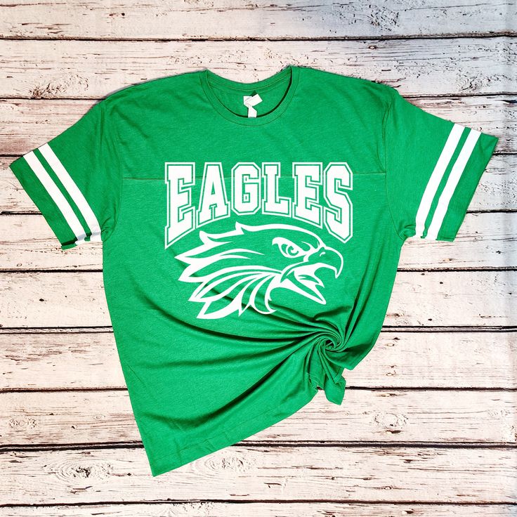 Introducing my Eagles school spirit lightweight jersey LAT tees, the perfect blend of softness, stretchiness, comfort, and cuteness! These tees are designed to elevate your school spirit wear to new levels of style and comfort. Crafted from high-quality lightweight material, these tees offer an exceptional softness that feels gentle against your skin. Embrace the comfort of these shirts, as they provide a cozy and luxurious feel that you'll never want to take off. The stretchy fabric ensures a p Eagles Mascot, Eagles Shirt, Eagles Team, School Spirit Wear, School Spirit Shirts, Football Tee, Eagle Shirts, Spirit Shirts, Team Shirt