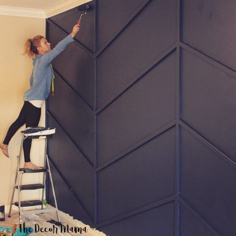 a woman on a ladder painting a wall