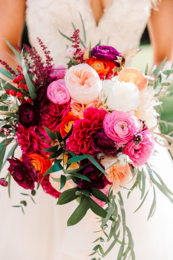 a bridal holding a bouquet of flowers and greenery