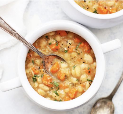 two white bowls filled with soup on top of a table