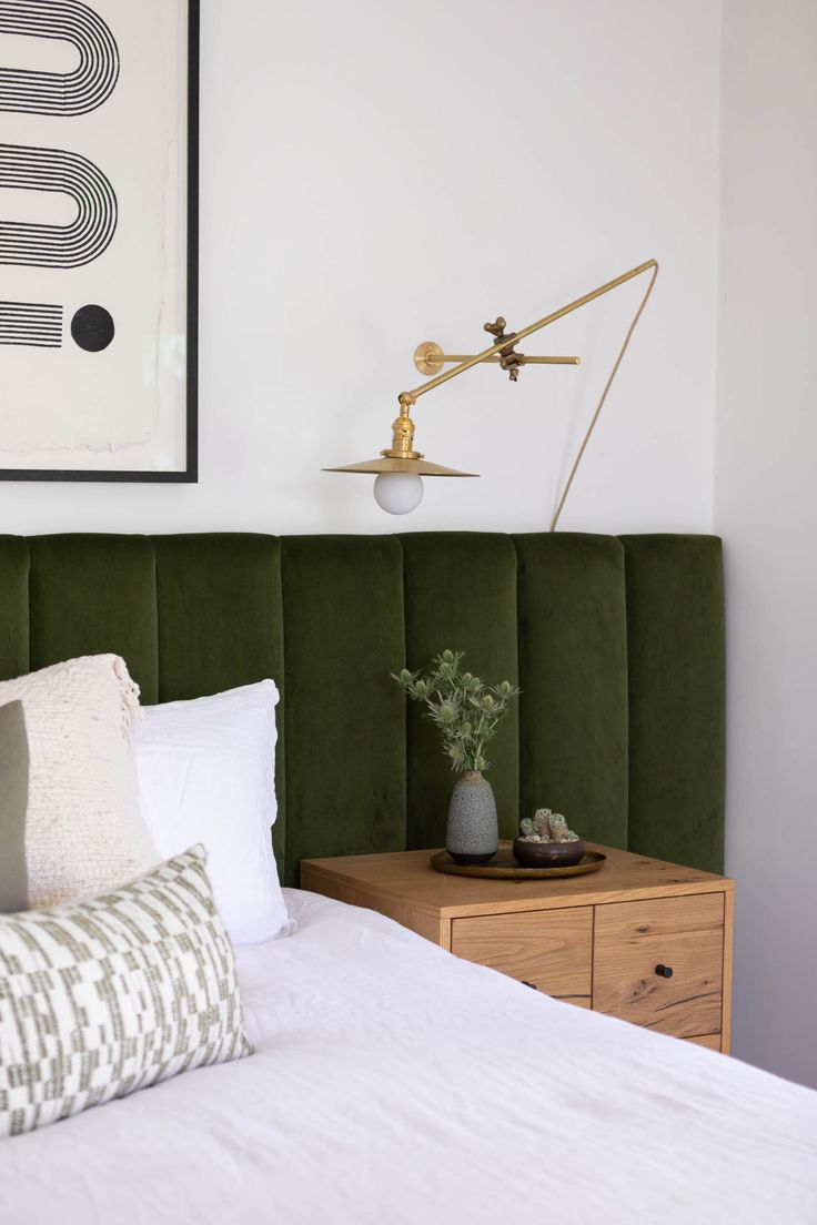 a green headboard in a white bedroom