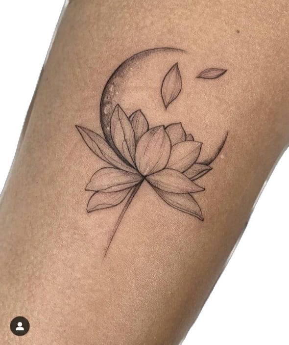 a woman's leg with a lotus tattoo on the side of her thigh and half moon