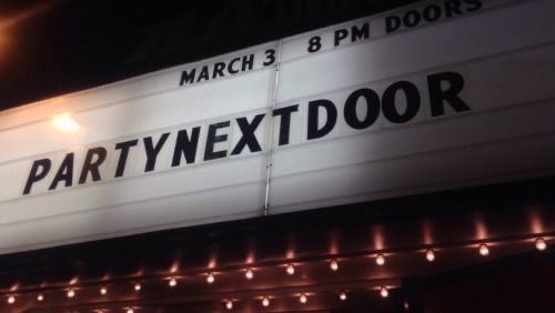 the marquee for party next door is lit up at night