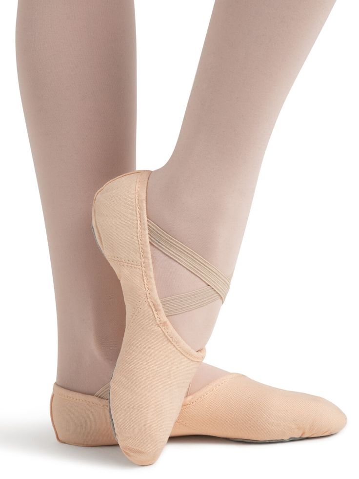 the feet of a ballerina in pink ballet shoes, with one leg wrapped around