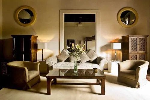 a living room with couches, chairs and a table in front of a mirror