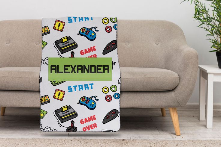 a blanket that is sitting on the floor in front of a couch with video game controllers