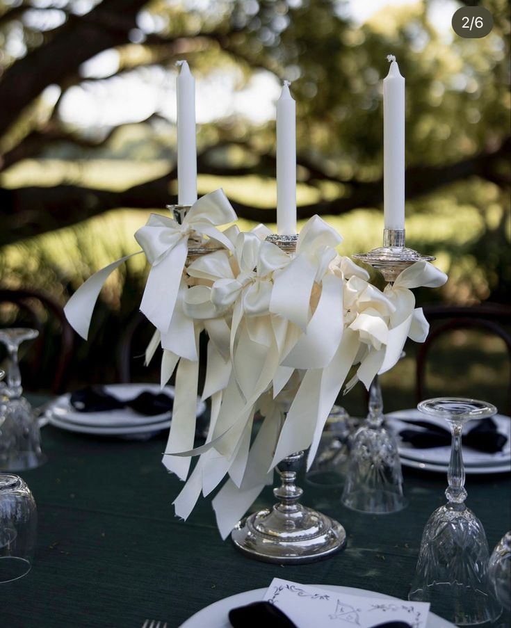 the table is set with candles and napkins for an elegant touch to the place setting