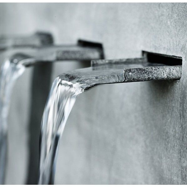 two water faucets running down the side of a wall next to each other