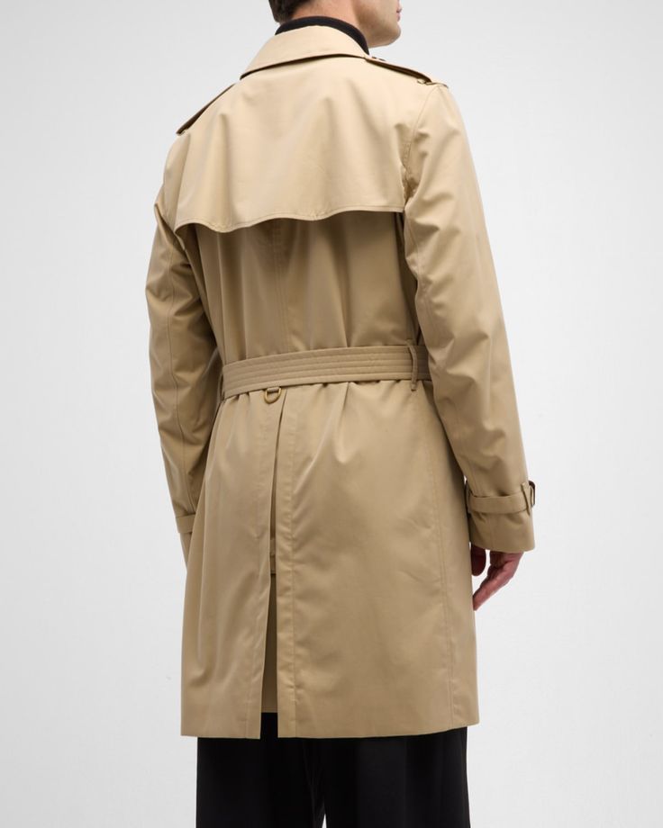 Burberry "Kensington" trench coat made from waterresistant gabardine    Hookandeye collar closure​    Throat latch    Shoulder epaulettes​    Belted waist and cuffs    Side button welt pockets​    Center back vent    Burberry Check lining and undercollar​    Buckles: calf leather    Cotton    Lining: Cotton/viscose    Made in United Kingdom Burberry Kensington Trench Coat, Shoulder Epaulettes, British Heritage, Global Brands, Cotton Viscose, Burberry Men, Welt Pockets, Welt Pocket, Calf Leather