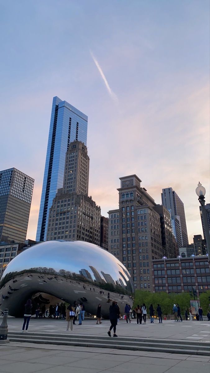 people are walking around in front of the cloud gate at chicago's millennium park