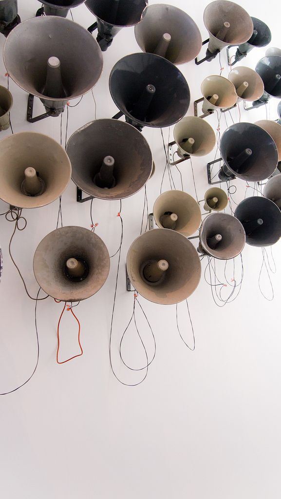 a bunch of different types of speakers hanging from the ceiling with wires attached to them