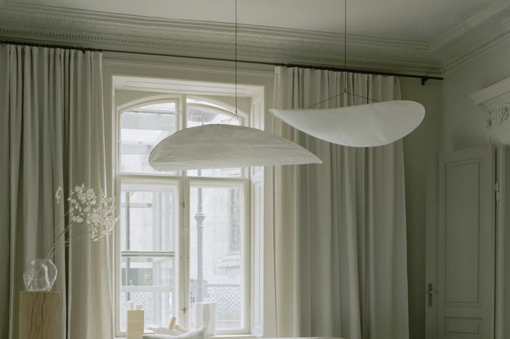 a living room filled with furniture and a large white lamp hanging over the top of it