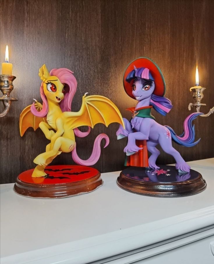 two little pony figurines sitting on top of a counter