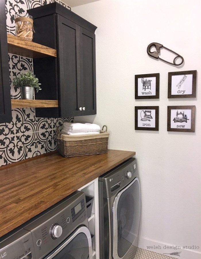 a washer and dryer in a room with pictures on the wall behind them