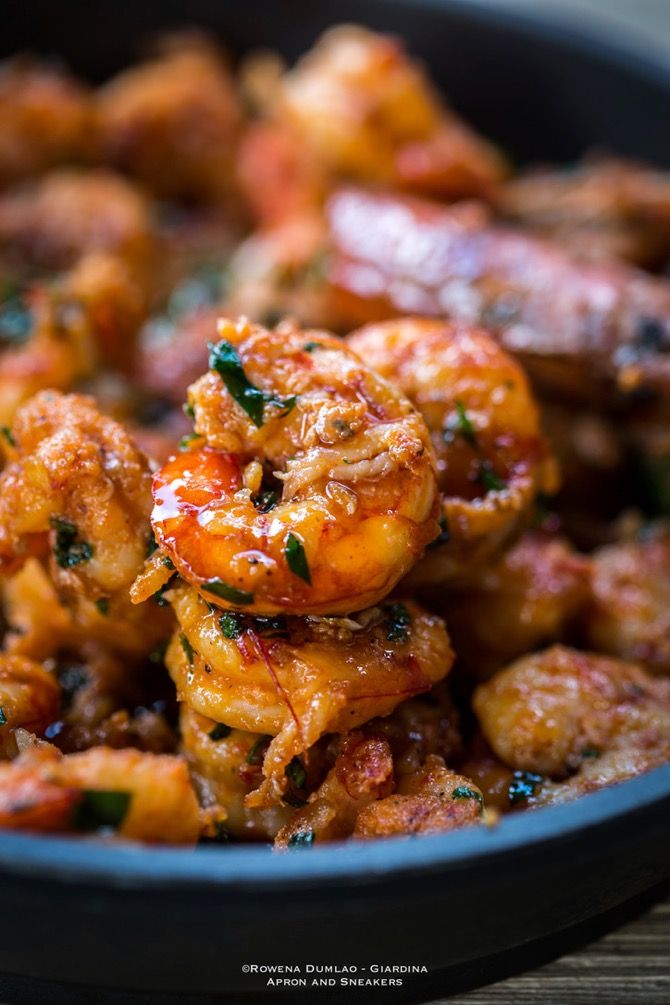 cooked shrimp with herbs in a black bowl