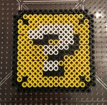 an image of a skull made out of legos on a table with black and yellow beads