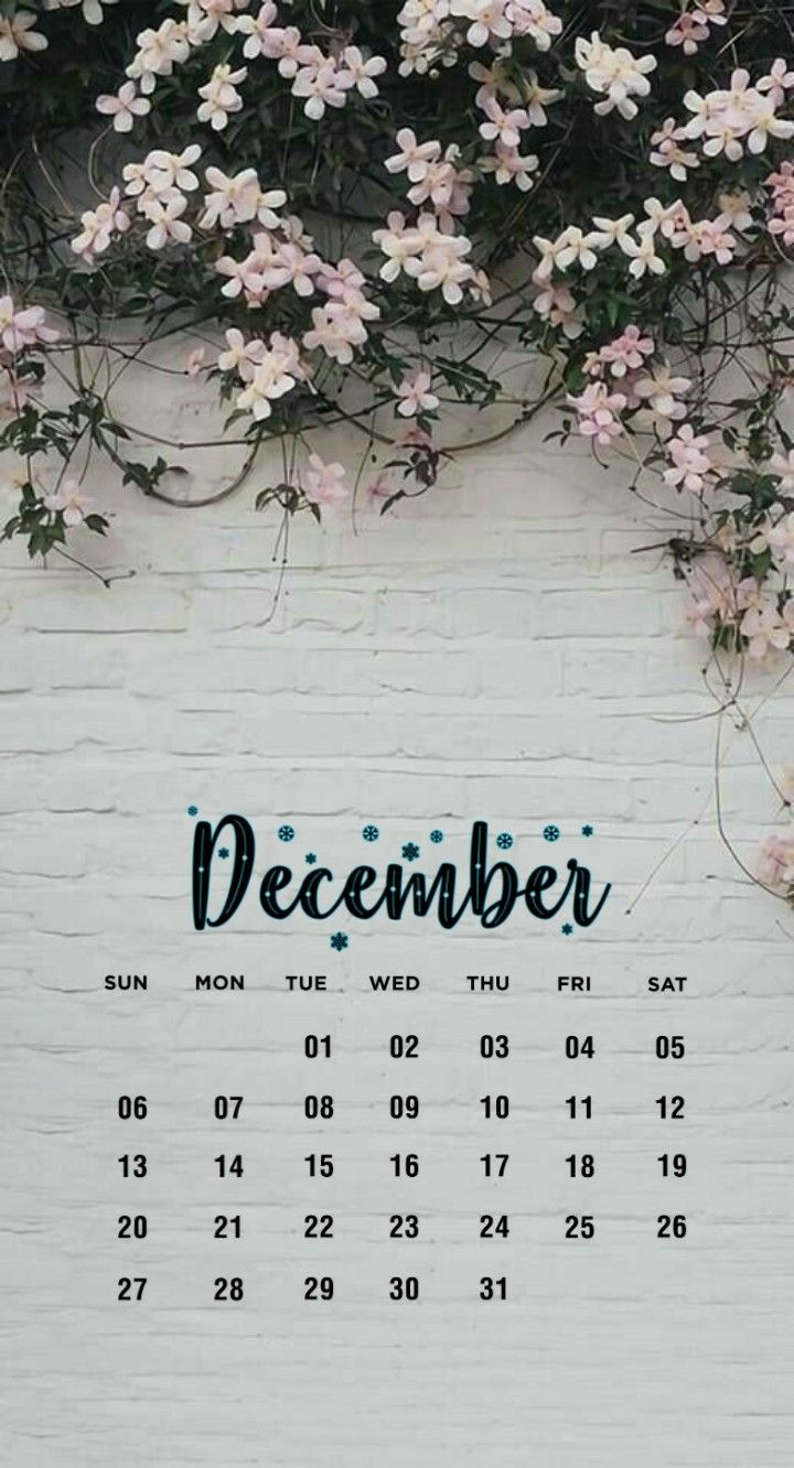 a white brick wall covered in flowers with the word december written on it's side