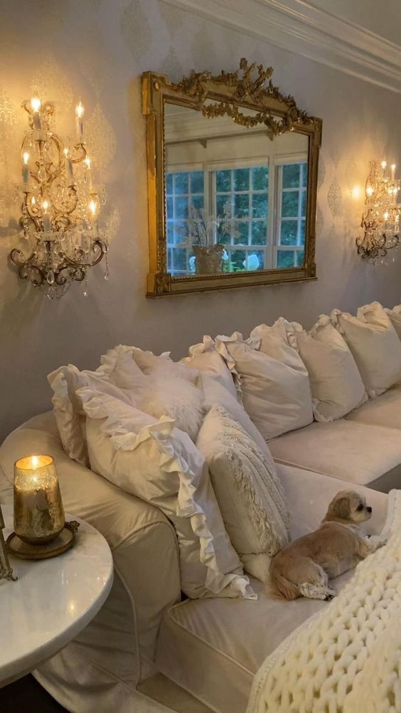 a white couch with pillows and a dog laying on it's back in front of a mirror