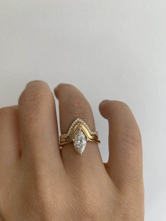 a woman's hand with a ring on it and a diamond in the middle