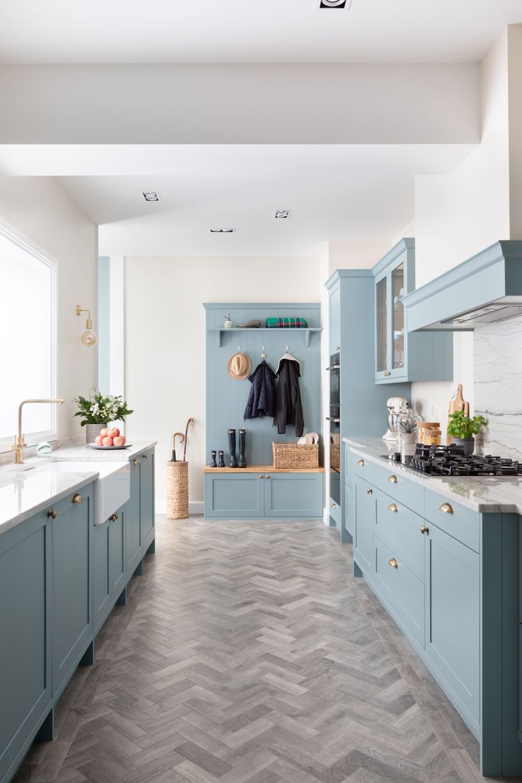 a kitchen with blue cabinets and marble counter tops