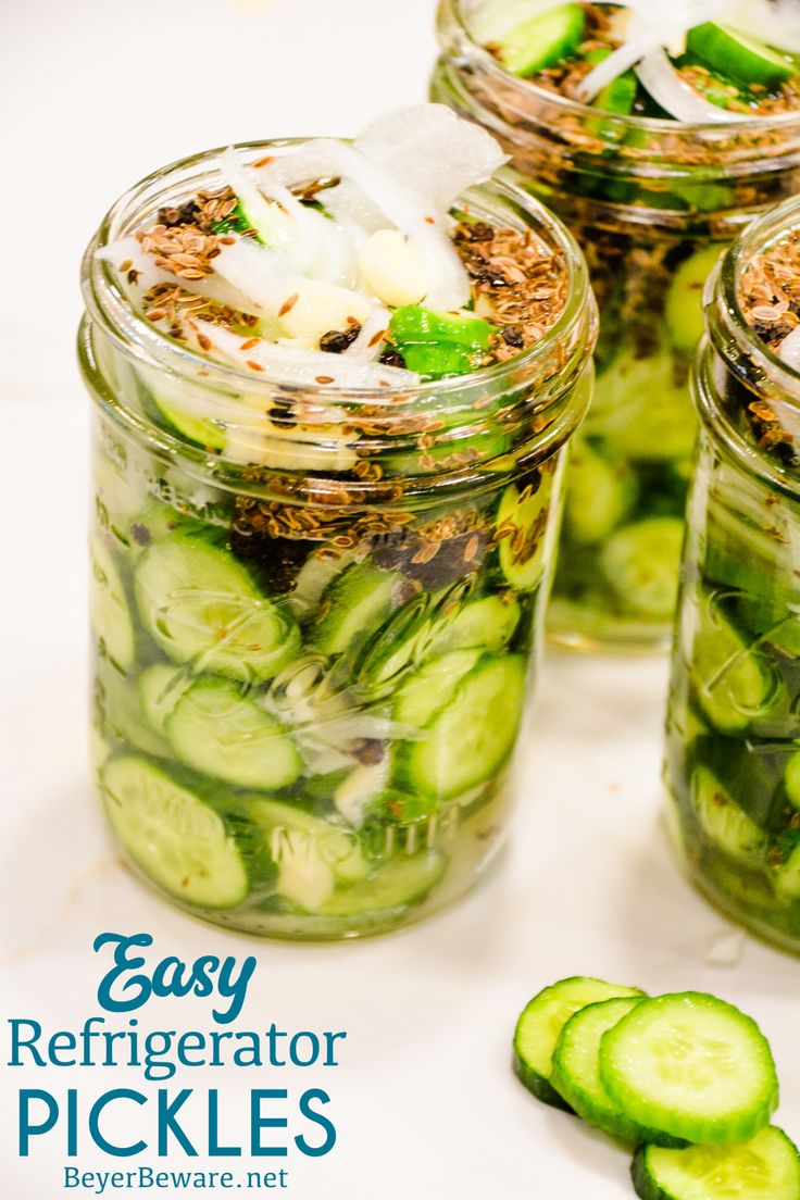 four mason jars filled with cucumber slices and seasoning next to each other